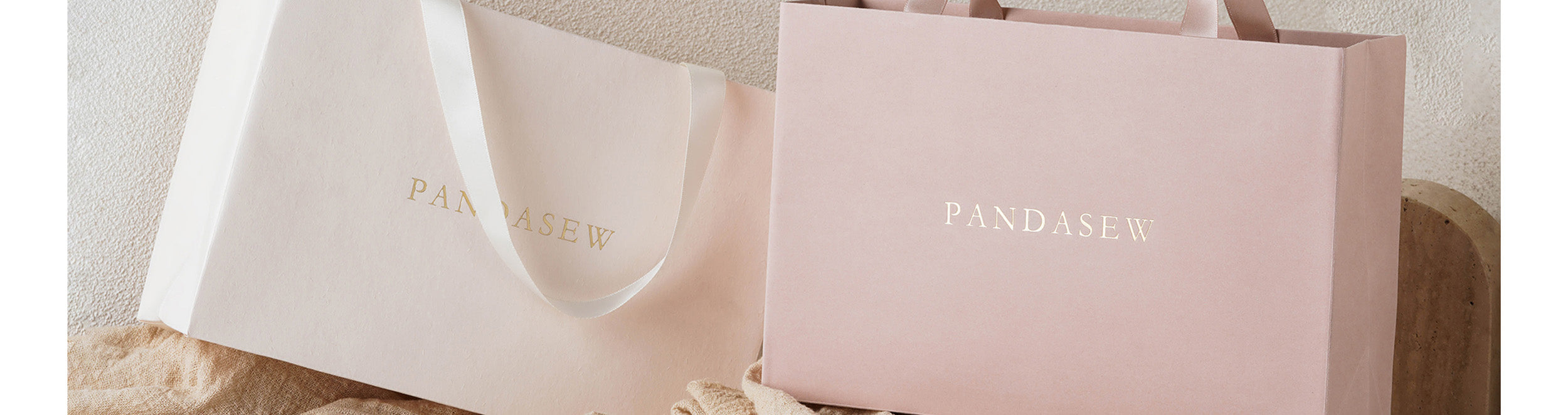 pink and ivory paper bag with gold logo